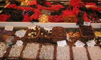 1416 | Marché - Espagne - Si le monde entier est aujourd'hui grand consommateur de chocolat, c'est aux conquérants Portugais et Espagnols qu'il le doit. Très peu apprécié au début, il ne servait alors que de monnaie d'échange avec l'or. Beaucoup plus tard, l'Europe entière conquise à son tour par le chocolat, lui donna ses lettres de noblessse. Un marché espagnol ne saurait exister sans son étal de confiseries et chocolats.