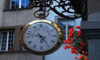 1667 | L'Heure - Une enseigne d'horloger, sur le mode typique des régions allémaniques.