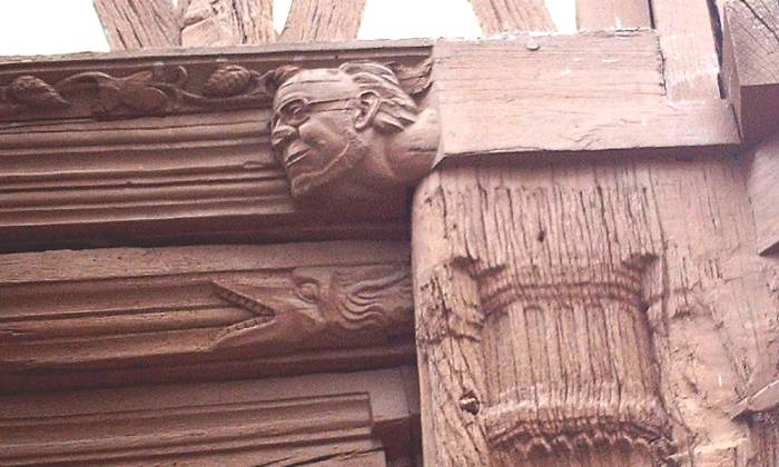 puzzle détails d'une façade, un «rageur» et une figure à lunettes sculptés sur une façade à Joigny